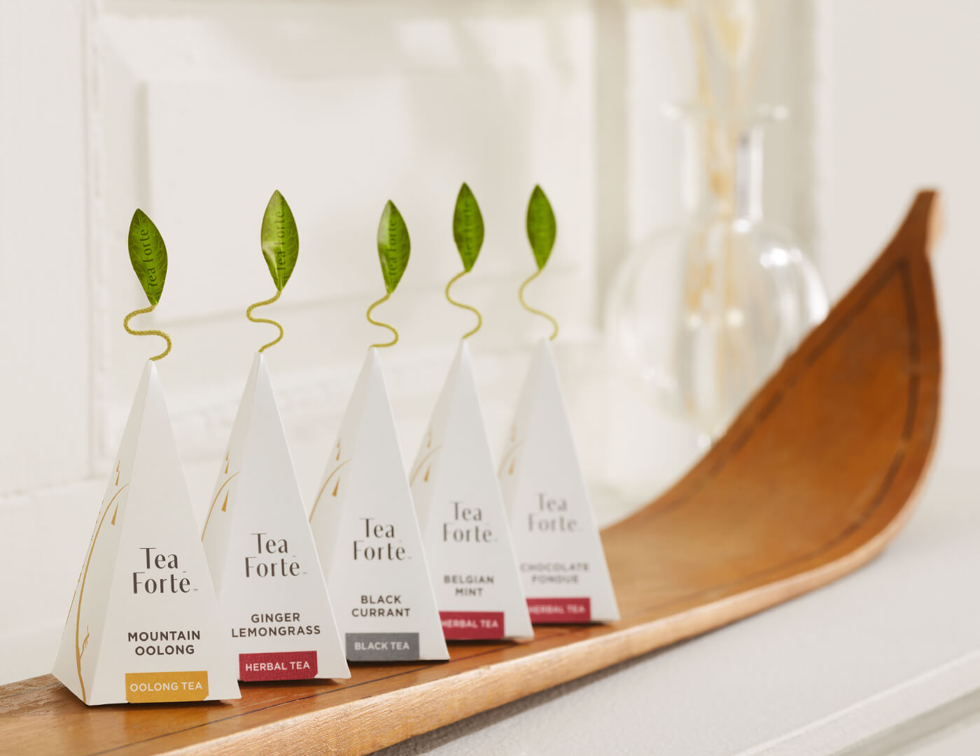 Tea Forte pyramid infusers  on a wooden ski with a blurred background